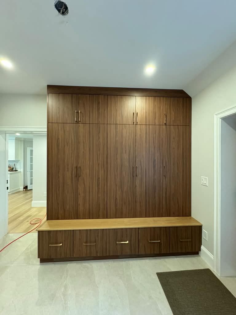 Walnut mudroom built-in with tall cabinets and a bench